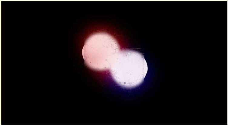 Two glowing orbs, one pink and one white, against a black background